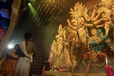 Howrah, Batı Bengal, Hindistan - 3 Ekim 2022: Hindu Rahibi Tanrıça Durga 'ya tapıyor. Ashtami puja aarati - Durga Puja ritüeli - Hinduizm festivali gece pandalında gerçekleştiriliyor.