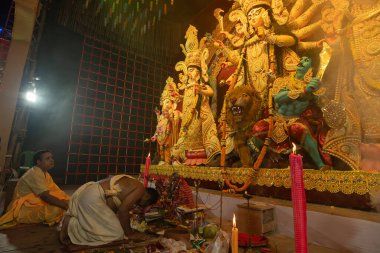 Howrah, Batı Bengal, Hindistan- 3 Ekim 2022: Hindu Rahip saygı göstererek, dua ederek ve tanrıça Durga 'ya taparak diz çöker. Puja Pandalı. Durga puja soyut, soyut bir kültür mirası..