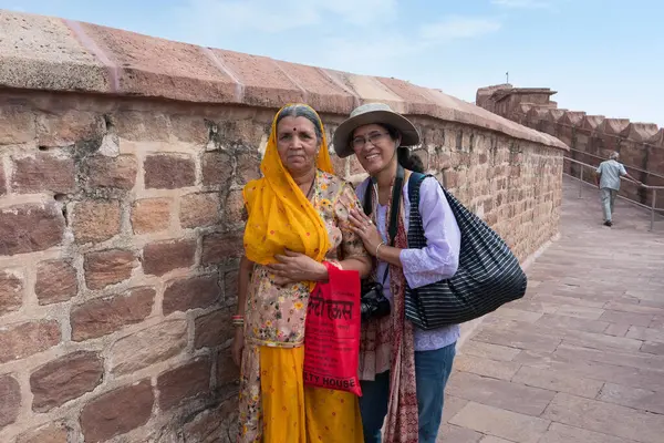 stock image Jodhpur, Rajasthan, India - 17th October, 2019 : Happy Indian modern female solo traveller posing with traditional dressed old Rajasthani woman, at way to Chamunda Mataji temple of Mehrangarh fort.