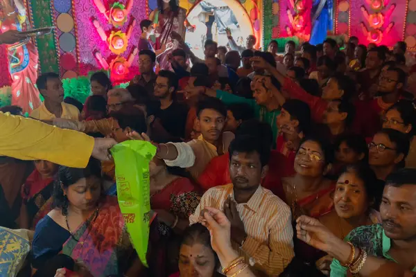 stock image Howrah,West Bengal,India- 3rd October, 2022 : Hindu devotees collecting flower petals after pushpanjali is over, a ritual for praying and worshipping Goddess Durga, inside decorated Durga Puja Pandal.