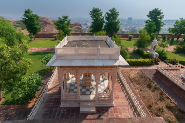 Gazebo at beautiful decorated garden of Jaswant Thada cenotaph. Garden has carved gazebos, a tiered garden, and a small lake with nice view. Thar desert and blue sky background. clipart