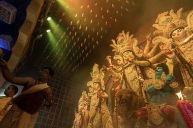 Howrah, Batı Bengal, Hindistan - 3 Ekim 2022: Hindu Rahibi Tanrıça Durga 'ya tapıyor. Ashtami puja aarati - Durga Puja ritüeli - Hinduizm festivali gece pandalında gerçekleştiriliyor.