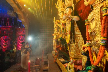 Howrah, Batı Bengal, Hindistan - 3 Ekim 2022: Hindu rahipler Tanrıça Durga 'ya aynayla tapıyorlar ki Tanrıça elbisesini görebilsin. Ashtami puja aarati - Durga Puja ritüeli - Hinduizm festivali.