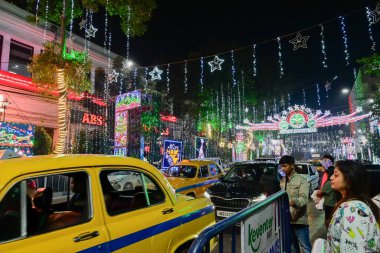 Kolkata, Batı Bengal, Hindistan - 24.12.2023: Park Caddesi 'nde Noel ışıklandırması. Meşhur sarı taksiler geceleri işlek Park Caddesinde parlıyordu. Vatandaşlar eğlence ve gece hayatının tadını çıkarmak için Park Caddesini ziyaret ediyor..