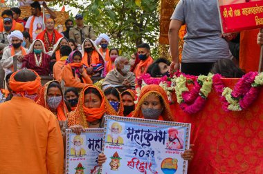 Haridwar, Uttarakhand, Hindistan - 13 Nisan 2021: Hindu sadhus, safran rengi parlak safran elbiseler içinde süslü araçlar, Ganj nehrinde shahi snaan için geçit töreni. Kumbhmela olayı.