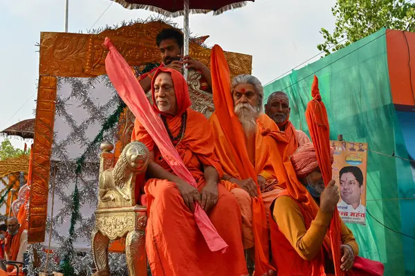 Haridwar, Uttarakhand, Hindistan - 13 Nisan 2021: Hindu sadhus, safran rengi parlak safran elbiseler içinde süslü araçlar, Ganj nehrinde shahi snaan için geçit töreni. Kumbhmela olayı.