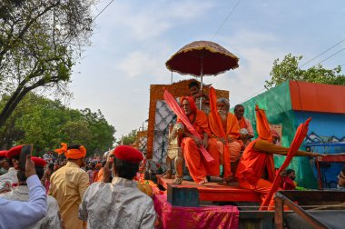 Haridwar, Uttarakhand, Hindistan - 13 Nisan 2021: Hindu sadhus, safran rengi parlak safran elbiseler içinde süslü araçlar, Ganj nehrinde shahi snaan için geçit töreni. Kumbhmela olayı.