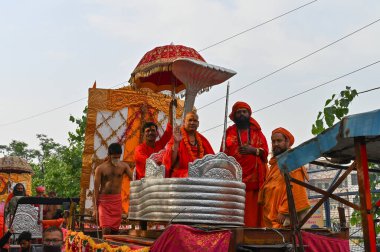 Haridwar, Uttarakhand, Hindistan - 13 Nisan 2021: Hindu sadhus, safran rengi parlak safran elbiseler içinde süslü araçlar, Ganj nehrinde shahi snaan için geçit töreni. Kumbhmela olayı.