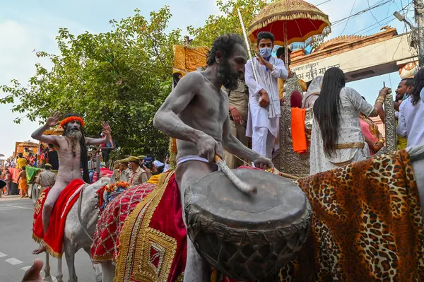 Haridwar, Uttarakhand, Hindistan - 13 Nisan 2021: Hindu çıplak sadhu, naga sanyasi veya naga baba domru ile ata biniyor ve Ganj Nehri 'nde shahi snaan için geçit töreni düzenliyor. Kumbhmela olayı.