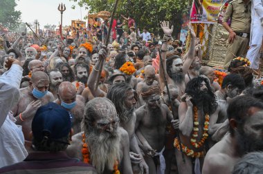 Haridwar, Uttarakhand, Hindistan - 13 Nisan 2021: Hindu çıplak sadhus, naga babas, naga sanyasis Ganj nehrinde shahi snaan yemek ve Har Har Mahadev diye bağırmak için koşuyor. Kumbhmela olayı.