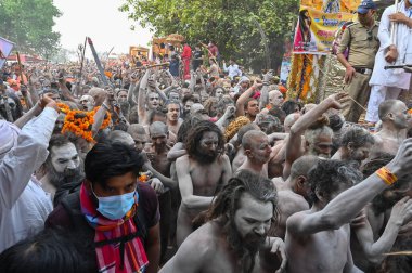 Haridwar, Uttarakhand, Hindistan - 13 Nisan 2021: Hindu çıplak sadhus, naga babas, naga sanyasis Ganj nehrinde shahi snaan yemek ve Har Har Mahadev diye bağırmak için koşuyor. Kumbhmela olayı.