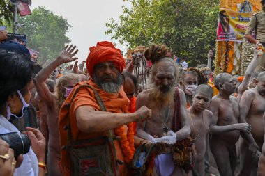 Haridwar, Uttarakhand, India - 13th April 2021 : Maha Kumbhmela event. Sadhu, sanyasi in bright saffron dresses walking in procession for shahi snaan on Holy river Ganges. Famous Hindu event. clipart