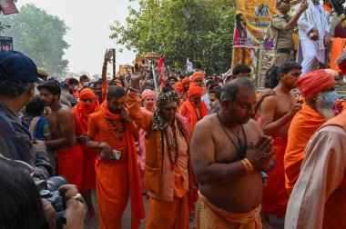 Haridwar, Uttarakhand, India - 13th April 2021 : Maha Kumbhmela event. Sadhu, sanyasi in bright saffron dresses walking in procession for shahi snaan on Holy river Ganges. Famous Hindu event. clipart