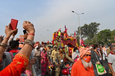 Haridwar, Uttarakhand, Hindistan - 13 Nisan 2021: Maha Kumbhmela etkinliği. Sadhus, safranlı Sanyasis Ganj nehrinde shahi snaan yemek için traktörlere biniyor. Kullarının ellerini kaldır..