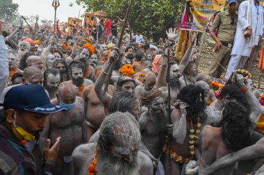 Haridwar, Uttarakhand, Hindistan - 13 Nisan 2021: Purno Kumbhmela etkinliği. Hindu çıplak sadhus, naga babas, naga sanyasis Ganj nehri üzerinde shahi snaan yemek ve Har Har Mahadev diye bağırmak için koşuyor..