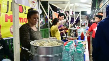 Kolkata, Batı Bengal, Hindistan - 24,12,2023: Park Caddesi 'nde Noel boyunca lezzetli yemek ve atıştırmalıkların tadını çıkaran vatandaşlar. İnsanlar Noel 'de eğlenmek için Park Caddesini ziyaret ediyor..