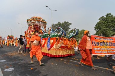 Haridwar, Uttarakhand, Hindistan - 13 Nisan 2021: Maha Kumbhmela etkinliği. Sadhus, safranlı Sanyasis Ganj nehrinde shahi snaan yemek için traktörlere biniyor. Kullarının ellerini kaldır..