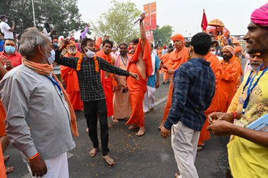 Haridwar, Uttarakhand, India - 13th April 2021 : Hindu sadhus, sanyasis in bright saffron dresses dancing in joy in procession for shahi snaan on Holy river Ganges. Maha Kumbhmela event, big festival. clipart