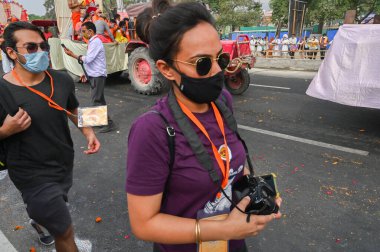 Haridwar, Uttarakhand, Hindistan - 13 Nisan 2021: Maha Kumbhmela etkinliği. Kameralı ve aletli haber ajansının genç bayan muhabiri Ganj Nehri 'nde Shahi Snaan için yürüyüş yapıyor..