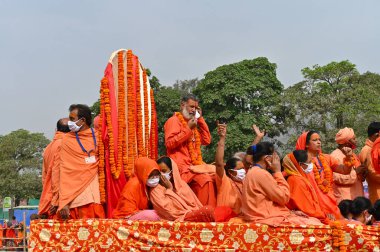Haridwar, Uttarakhand, Hindistan - 13 Nisan 2021: Maha Kumbhmela etkinliği. Sadhus, safranlı Sanyasis Ganj nehrinde shahi snaan yemek için traktörlere biniyor. Kullarının ellerini kaldır..