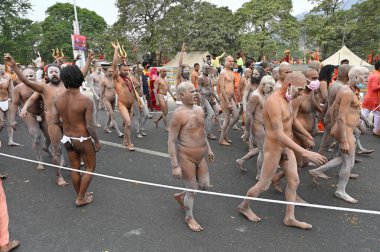 Haridwar, Uttarakhand, India - 13th April 2021 : Purno Kumbhmela event.Hindu naked sadhus, naga babas, naga sanyasis running for having shahi snaan on river Ganges and shouting Har Har Mahadev. clipart