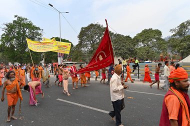 Haridwar, Uttarakhand, Hindistan - 13 Nisan 2021: Maha Kumbhmela etkinliği. Sadhus, parlak safran bayraklı sanyasiler Ganj Nehri 'ndeki shahi snaan için geçit töreni düzenlenmişti. Hindu etkinliği.