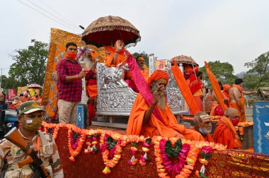 Haridwar, Uttarakhand, Hindistan - 13 Nisan 2021: Maha Kumbhmela etkinliği. Sadhus, safranlı Sanyasis Ganj nehrinde shahi snaan yemek için traktörlere biniyor. Kullarının ellerini kaldır..