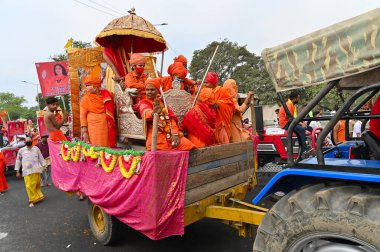 Haridwar, Uttarakhand, Hindistan - 13 Nisan 2021: Hindu sadhus, safran elbiseli sanyasis traktörlere binmiş Ganj Nehri 'ndeki shahi snaan için tören alayı. Maha Kumbhmela etkinliği, Hinduizm Hindistan 'da.