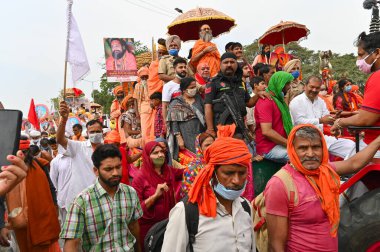 Haridwar, Uttarakhand, Hindistan - 13 Nisan 2021: Maha Kumbhmela etkinliği. Sadhus, safranlı Sanyasis Ganj nehrinde shahi snaan yemek için traktörlere biniyor. Kullarının ellerini kaldır..