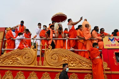 Haridwar, Uttarakhand, Hindistan - 13 Nisan 2021: Maha Kumbhmela etkinliği. Sadhus, safranlı Sanyasis Ganj nehrinde shahi snaan yemek için traktörlere biniyor. Kullarının ellerini kaldır..