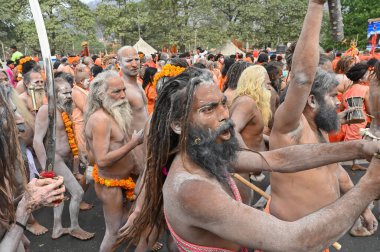 Haridwar, Uttarakhand, Hindistan - 13 Nisan 2021: Hindu çıplak sadhus, naga babas, naga sanyasis Ganj nehrinde shahi snaan yemek ve Har Har Mahadev diye bağırmak için koşuyor. Kumbhmela olayı.
