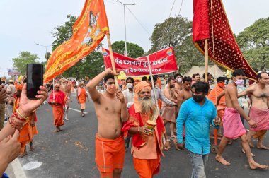 Haridwar, Uttarakhand, Hindistan - 13 Nisan 2021: Maha Kumbhmela etkinliği. Sadhus, parlak safran bayraklı sanyasiler Ganj Nehri 'ndeki shahi snaan için geçit töreni düzenlenmişti. Hindu etkinliği.