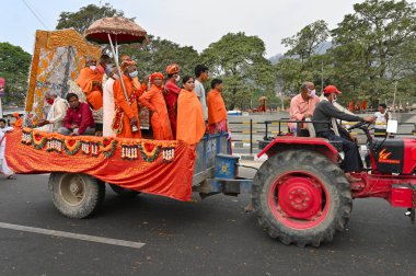 Haridwar, Uttarakhand, Hindistan - 13 Nisan 2021: Hindu sadhus, safran elbiseli sanyasis traktörlere binmiş Ganj Nehri 'ndeki shahi snaan için tören alayı. Maha Kumbhmela etkinliği, Hinduizm Hindistan 'da.