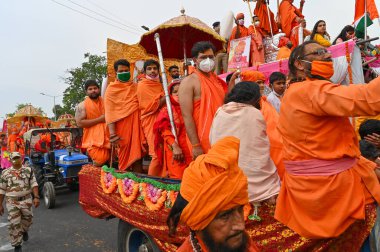 Haridwar, Uttarakhand, Hindistan - 13 Nisan 2021: Maha Kumbhmela etkinliği. Sadhus, safranlı Sanyasis Ganj nehrinde shahi snaan yemek için traktörlere biniyor. Kullarının ellerini kaldır..