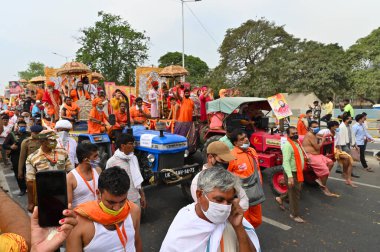 Haridwar, Uttarakhand, Hindistan - 13 Nisan 2021: Maha Kumbhmela etkinliği. Sadhus, safranlı Sanyasis Ganj nehrinde shahi snaan yemek için traktörlere biniyor. Kullarının ellerini kaldır..