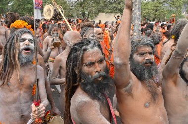 Haridwar, Uttarakhand, Hindistan - 13 Nisan 2021: Hindu çıplak sadhus, naga babas, naga sanyasis kutsanmışlığı Ganj Nehri 'nde shahi snaan yemeden ve Har Har Mahadev.Kumbhmela etkinliği diye bağırmadan önce..