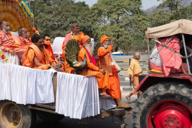 Haridwar, Uttarakhand, Hindistan - 16 Nisan 2021: Maha Kumbhmela etkinliği. Sadhus, safranlı Sanyasis Ganj nehrinde shahi snaan yemek için traktörlere biniyor. Kullarının ellerini kaldır..
