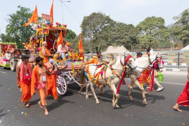 Haridwar, Uttarakhand, Hindistan - 16 Nisan 2021: Hindu sadhus, safran elbiseli sanyasiler atlar tarafından Ganj Nehri 'ndeki shahi snaan için çekiliyor. Maha Kumbhmela etkinliği, Hinduizm, Hindistan.