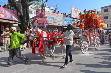 Haridwar, Uttarakhand, Hindistan - 15 Nisan 2021: Hindu sadhus, safran elbiseli sanyasiler atlar tarafından Ganj Nehri 'ndeki shahi snaan için çekiliyor. Maha Kumbhmela etkinliği, Hinduizm, Hindistan.