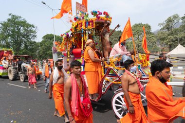 Haridwar, Uttarakhand, Hindistan - 16 Nisan 2021: Hindu sadhus, safran elbiseli sanyasiler atlar tarafından Ganj Nehri 'ndeki shahi snaan için çekiliyor. Maha Kumbhmela etkinliği, Hinduizm, Hindistan.