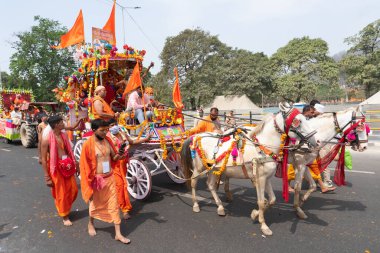 Haridwar, Uttarakhand, Hindistan - 16 Nisan 2021: Hindu sadhus, safran elbiseli sanyasiler atlar tarafından Ganj Nehri 'ndeki shahi snaan için çekiliyor. Maha Kumbhmela etkinliği, Hinduizm, Hindistan.