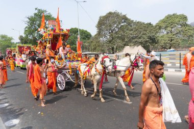 Haridwar, Uttarakhand, Hindistan - 16 Nisan 2021: Hindu sadhus, safran elbiseli sanyasiler atlar tarafından Ganj Nehri 'ndeki shahi snaan için çekiliyor. Maha Kumbhmela etkinliği, Hinduizm, Hindistan.