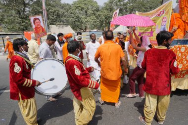 Haridwar, Uttarakhand, Hindistan - 16 Nisan 2021: Maha Kumbhmela etkinliği. Parlak elbiseli Hindu fanatikler Ganj Nehri 'nde Shahi snaan yemek için neşe içinde dans ediyorlar. Müzik çalan grup partisi.