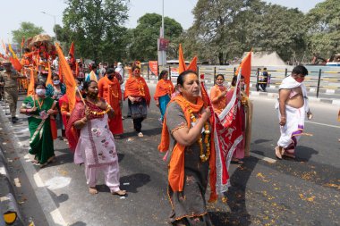 Haridwar, Uttarakhand, Hindistan - 16 Nisan 2021: Hindu kadınlar Ganj Nehri 'nde shahi snaan yemek için geçit töreninde ellerinde bayraklar tutan maskeli kadınlar. Kutsal Maha Kumbhmela etkinliği.