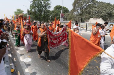 Haridwar, Uttarakhand, Hindistan - 16 Nisan 2021: Hindu kadınlar Ganj Nehri 'nde shahi snaan yemek için geçit töreninde ellerinde bayraklar tutan maskeli kadınlar. Kutsal Maha Kumbhmela etkinliği.
