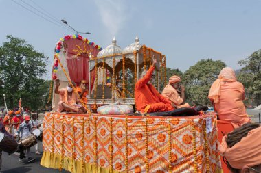 Haridwar, Uttarakhand, Hindistan - 16 Nisan 2021: Maha Kumbhmela etkinliği. Sadhus, safranlı Sanyasis Ganj nehrinde shahi snaan yemek için traktörlere biniyor. Kullarının ellerini kaldır..