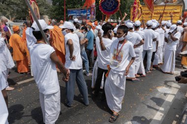 Haridwar, Uttarakhand, India - 16th April 2021 : Maha Kumbhmela event. Sadhus, sanyasis in white dresses with flags held high walking in procession for shahi snaan on Holy river Ganges. Hindu event. clipart