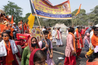 Haridwar, Uttarakhand, Hindistan - 16 Nisan 2021: Hindu rahipler, sadhus, safran elbiseli sanyasiler Ganj Nehri 'ndeki Shahi snaan için geçit töreni yapıyorlar. Maha Kumbhmela etkinliği, Hinduizm.