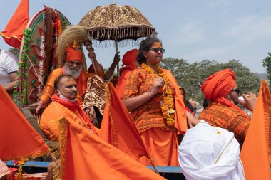 Haridwar, Uttarakhand, Hindistan - 16 Nisan 2021: Hindu rahipler, sadhus, safran elbiseli sanyasiler, Ganj Nehri 'ndeki Shahi Snaan için traktörler giyiyorlar. Maha Kumbhmela etkinliği, Hinduizm, Hindistan.