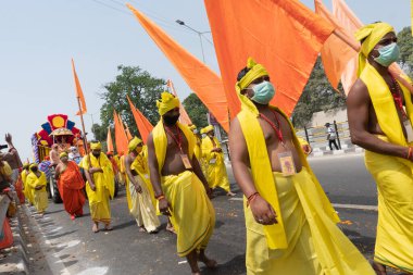 Haridwar, Uttarakhand, Hindistan - 16 Nisan 2021: Maha Kumbhmela etkinliği. Sadhus, sanyasis, dini bayraklı sarı elbiseli rahipler Ganj Nehri 'nde shahi snaan yemek için tören alayında yüksekte yürüyorlardı..
